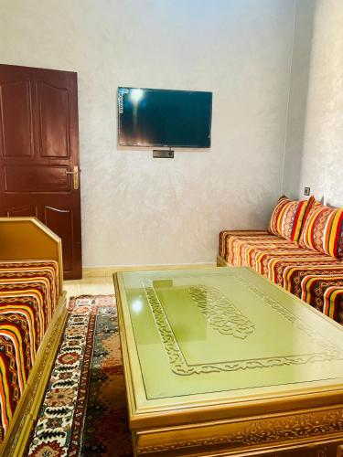 sala de estar con 2 sofás y TV de pantalla plana en SAHARA APPARTEMENTS, en Merzouga
