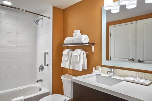 a bathroom with a sink and a toilet and a mirror at TownePlace Suites by Marriott Fort McMurray in Fort McMurray