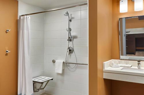 a bathroom with a shower and a sink at TownePlace Suites by Marriott Fort McMurray in Fort McMurray