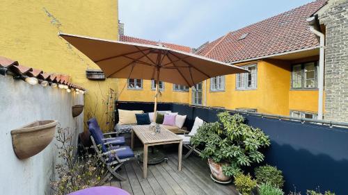 patio z parasolem, stołem i krzesłami w obiekcie ApartmentInCopenhagen Apartment 1597 w Kopenhadze