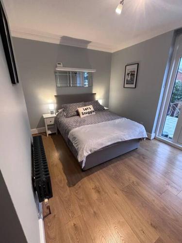 1 dormitorio con 1 cama y suelo de madera en Priory park view, en Southend-on-Sea