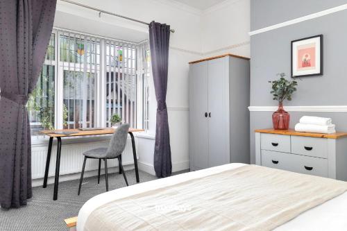 um quarto com uma cama, uma secretária e uma janela em NEW Oakhill House by Truestays - 5 Bedroom House in Stoke-on-Trent em Trent Vale