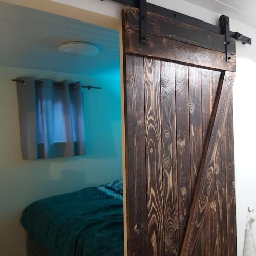 una porta in legno in una camera con letto di La petite souche a Rochefort