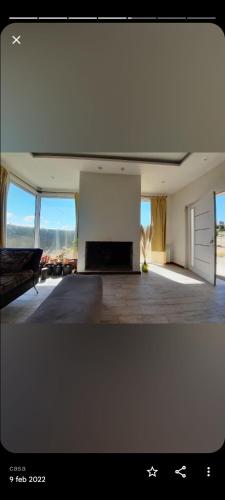 una gran sala de estar con chimenea y ventanas en OLIEMI en El Calafate