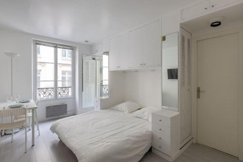 une chambre blanche avec un lit et une table dans l'établissement Le LONGCHAMP Paris 16 ème, New and perfectly located apartment, à Paris