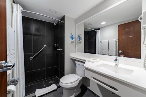 a bathroom with a toilet and a sink and a shower at City Express by Marriott Salina Cruz in Salina Cruz