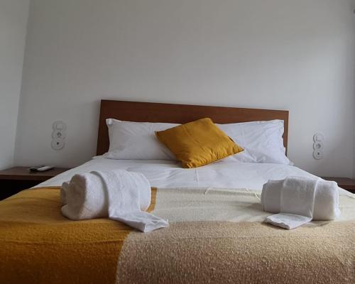 a bed with two towels sitting on top of it at O Pôr do Sol do Gerês in Paradela