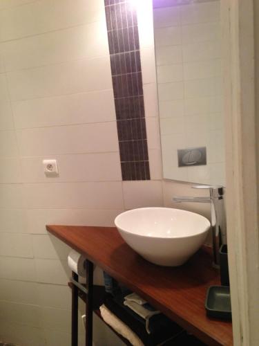 Charmant appartement 3 pers Perrache Confluence في ليون: حمام مع حوض أبيض على منضدة خشبية