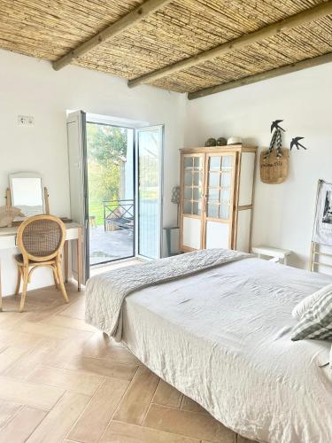a bedroom with a bed and a table and a desk at La Quinta da Liberdade - Ferme de charme en Algarve in Pechão