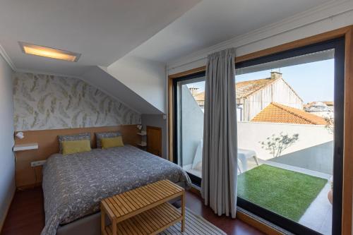1 dormitorio con cama y ventana grande en Top floor apartment with Sunny Balconies, en Oporto