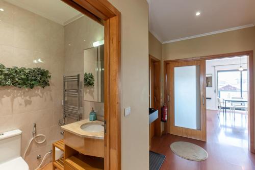 La salle de bains est pourvue d'un lavabo et d'un miroir. dans l'établissement Top floor apartment with Sunny Balconies, à Porto