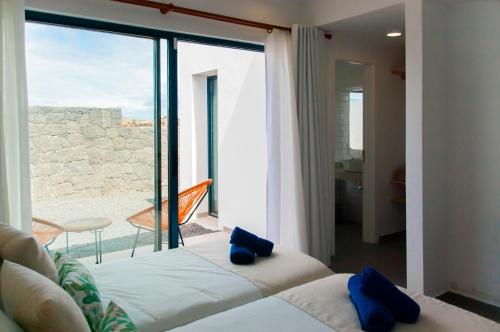 Un dormitorio con un gran ventanal con vista al mar. en Pasito Luxury Villa, en Charco del Palo