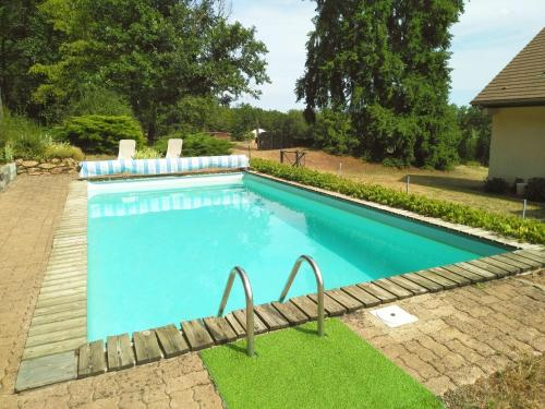a swimming pool with blue water in a yard at Yourte et nature in Magnien