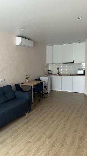 a living room with a blue couch and a kitchen at ЖК «Сонячний квартал» in Solochin