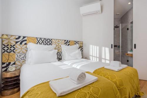 - une chambre avec 2 lits et des serviettes dans l'établissement Be Local - Historic house of Santo André in Alfama - Lisbon, à Lisbonne