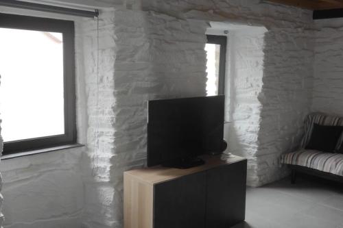 a living room with a flat screen tv on a cabinet at Da Silva house in Seia