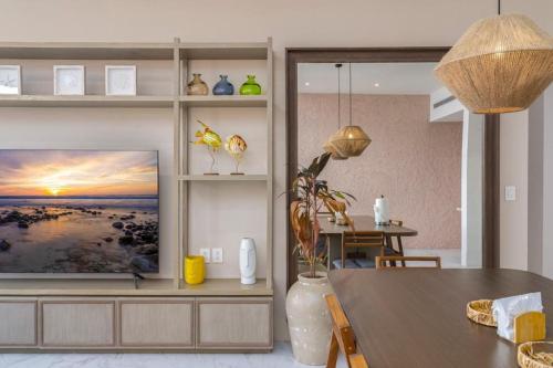 a living room with a television and a dining room table at New 3BR condo with exceptional location with pool in Cabo San Lucas