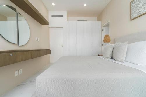 a bedroom with a large white bed and a mirror at New 3BR condo with exceptional location with pool in Cabo San Lucas