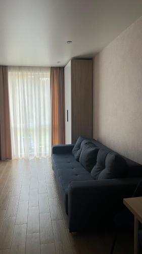 a large blue couch in a room with a window at ЖК «Сонячний квартал» in Solochin