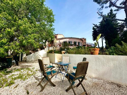 une table et des chaises devant une maison dans l'établissement VILLA ENTIÈRE PORT et PLAGE BANDOL, à Bandol