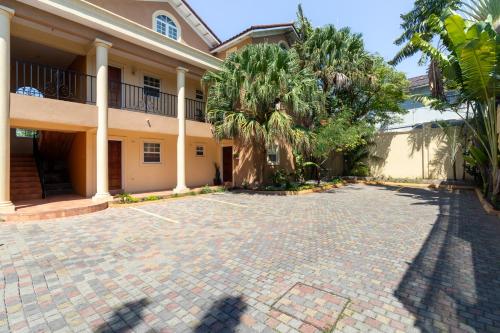 a courtyard with palm trees and a building at Cozy, upscale apartment centrally located in Kgn 6 in Kingston