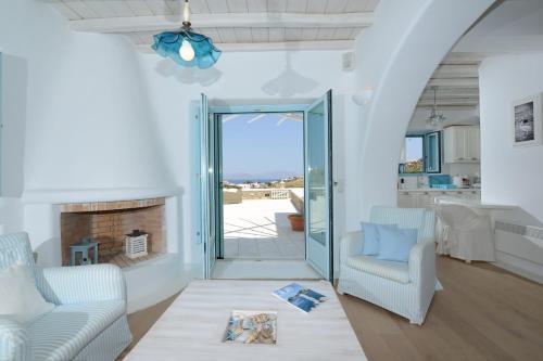 a living room with two chairs and a fireplace at Villa Danelina by Whitelist Mykonos in Ornos