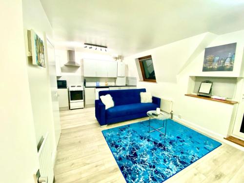 a living room with a blue couch and a blue rug at Cozy One Bedroom Apartment With Free Car Park In London in London