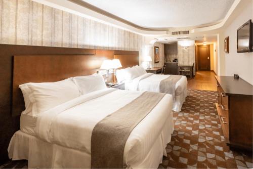 ein Hotelzimmer mit 2 Betten und einem Schreibtisch in der Unterkunft Hotel Plaza San Martin in Tegucigalpa