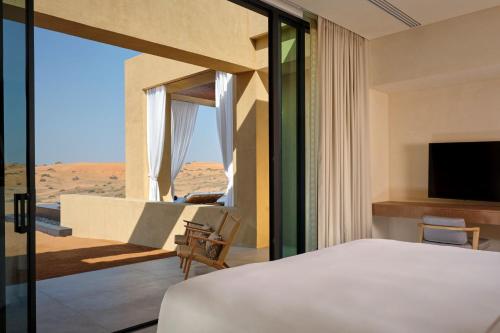 Schlafzimmer mit einem Bett und Blick auf die Wüste in der Unterkunft The Ritz-Carlton Ras Al Khaimah, Al Wadi Desert in Ras al Khaimah