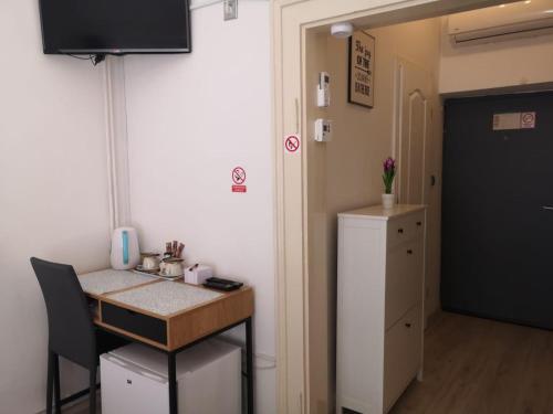 um pequeno quarto com uma mesa e um frigorífico em City centre room em Zagreb