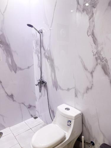 a white bathroom with a toilet and a shower at Luxury Apartment 21 in Riyadh