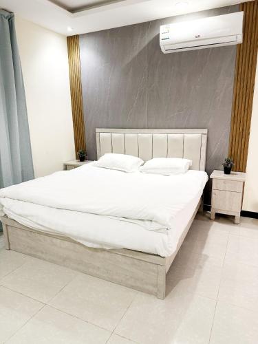 sypialnia z dużym łóżkiem z białą pościelą i poduszkami w obiekcie Luxury Apartment 21 w Rijadzie