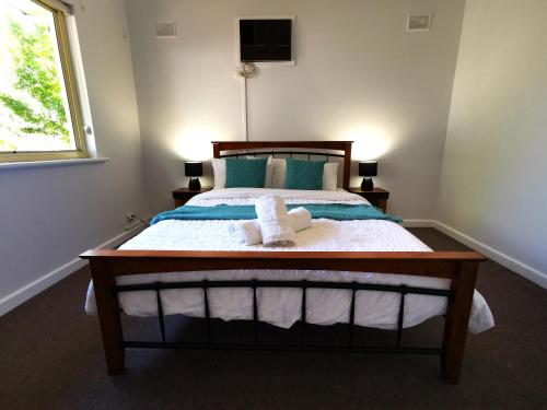 a bedroom with a bed with two towels on it at The Winemakers Quarters in Tanunda
