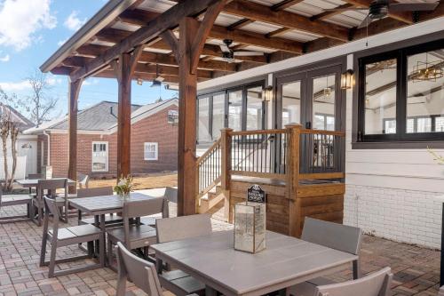 a patio with tables and chairs and a deck at 27 on Park Boutique Hotel & Venue in Dahlonega