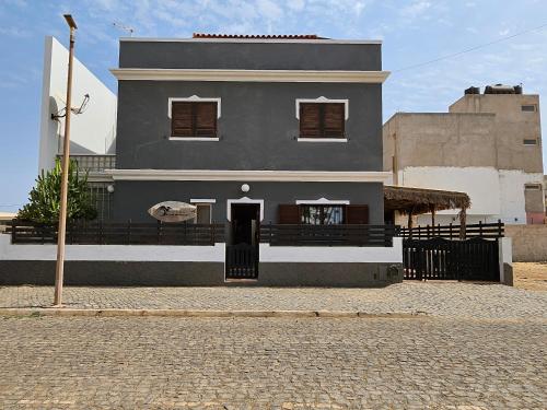 a gray house with a black door on a street at Águia in Santa Maria