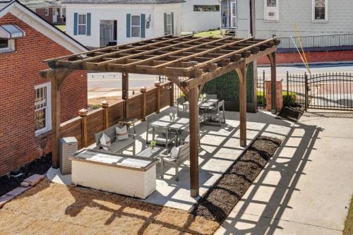 a patio with a wooden pergola with chairs under it at 27 on Park Boutique Hotel & Venue in Dahlonega