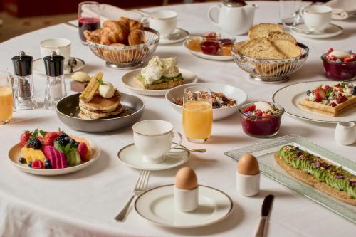 a table topped with plates of breakfast foods and fruit at Park Hyatt Melbourne in Melbourne