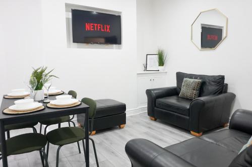 a living room with a table and a chair at Central Location Liverpool, Modern Home, 4 BR, Sleeps 9, Free Parking in Liverpool