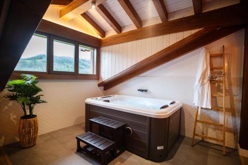 ein großes Bad mit einer großen Badewanne im Dachgeschoss in der Unterkunft Casa Rural Kabia in Arráyoz