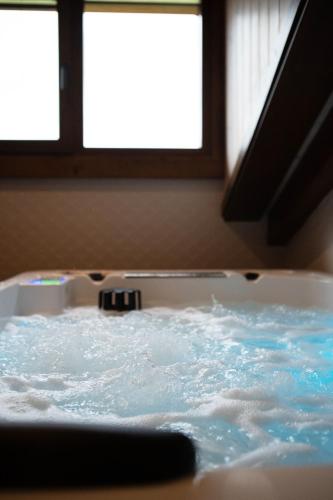 a bath tub filled with water next to a window at Casa Rural Kabia in Arráyoz