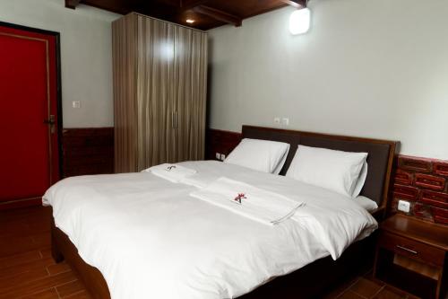 a large white bed with a red cross on it at KC GuestHouse in Yaoundé