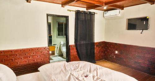 a room with a shower and a television in a room at KC GuestHouse in Yaoundé