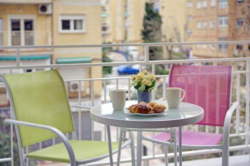 a table and chairs with a plate of food on a balcony at Apartamento en Fontiveros in Granada