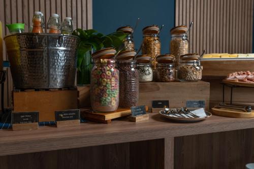 a group of jars sitting on a wooden shelf at GHL Hotel Barranquilla in Barranquilla