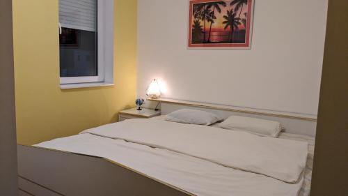 uma cama branca num quarto com uma janela em Apartman PRESSTIGE em Smederevska Palanka
