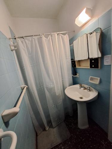a bathroom with a shower curtain and a sink at Belgrano Home - Casa con jardín cerca del Aeropuerto de Ezeiza, hasta 7 pax in Monte Grande