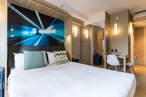 um quarto de hotel com uma cama grande e uma secretária em Charlie Alphaville em Barueri