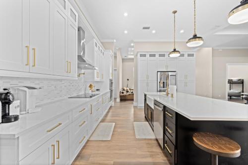 a large kitchen with white cabinets and a counter top at Eden's Endless Escape in Naples