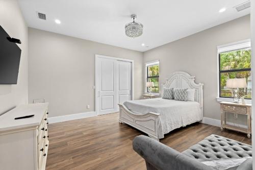 a white bedroom with a bed and a couch at Eden's Endless Escape in Naples