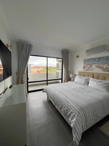 a bedroom with a bed and a large window at Retiro do Sossego in Sagres